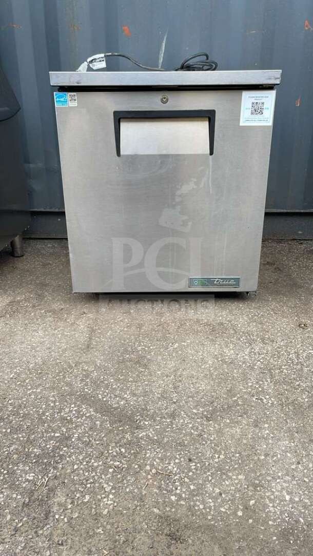 True TUC-27-HC undercounter refrigerator, stainless steel, model label visible, good condition, shown on concrete surface.