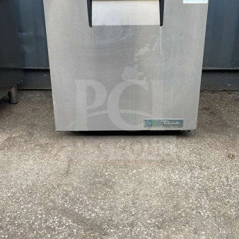 True TUC-27-HC undercounter refrigerator, stainless steel, model label visible, good condition, shown on concrete surface.