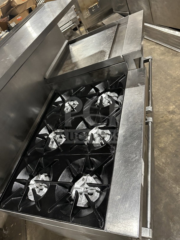 Stainless steel gas-powered 6-burner and grille with two standard ovens on casters, excellent condition.