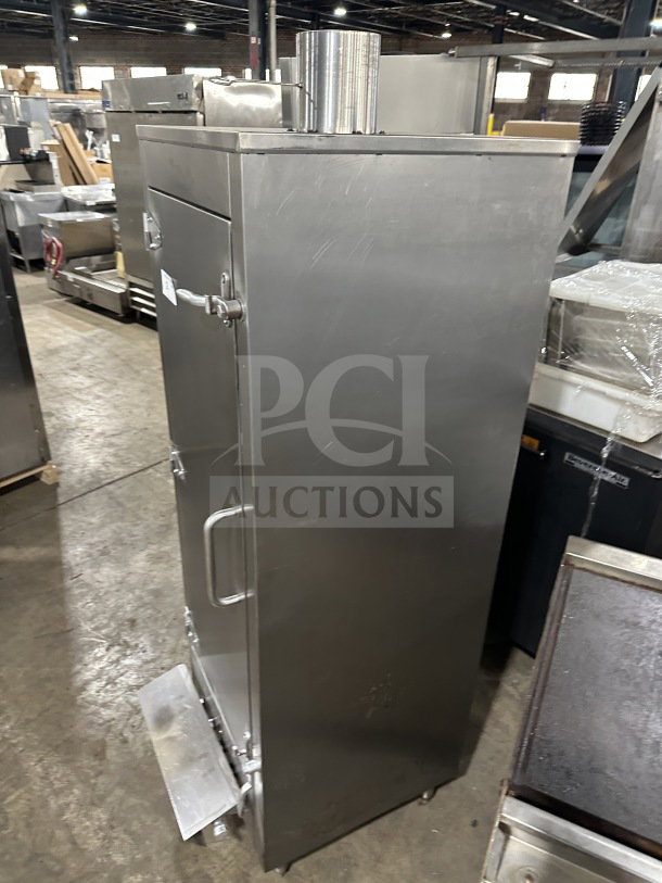 Commercial stainless steel smoker oven with galvanized interior on legs, featuring a front door handle and vent stack.