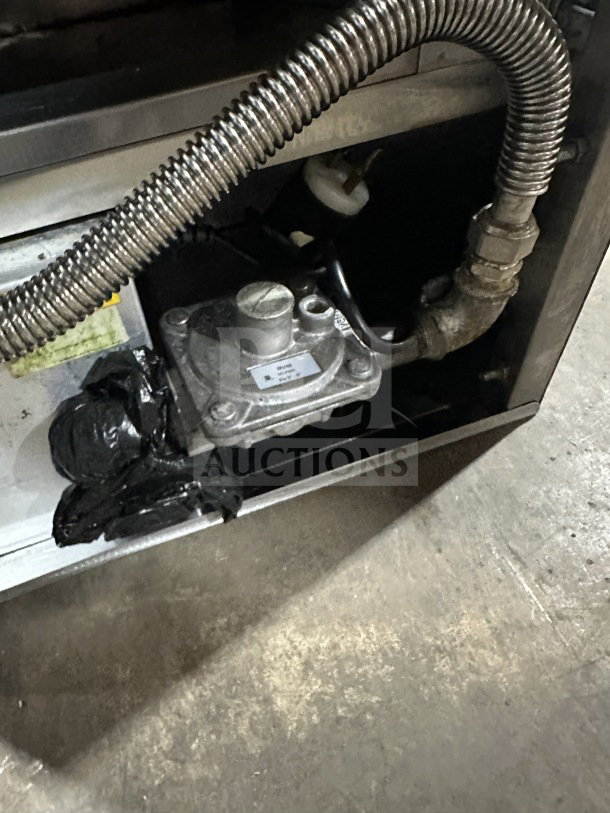 Sheffcat stainless steel 5-burner gas vertical broiler with coiled gas pipe, control valve, and visible usage markings.