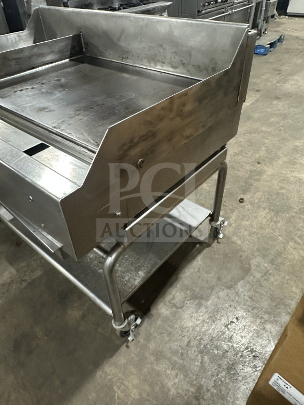 Commercial stainless steel gas griddle plancha with thermostatic control, integrated divider, stand, and casters.