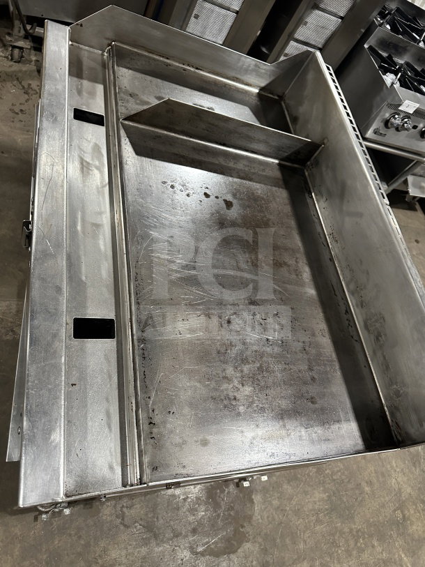 Commercial stainless steel gas-powered griddle with thermostatic controls, integrated divider, and stand on casters.