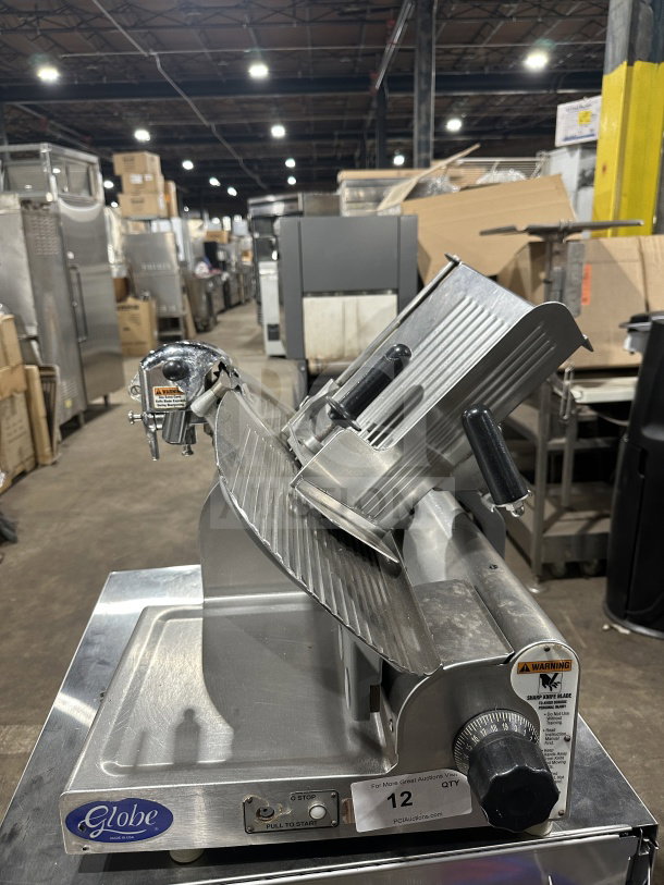 Chefmate Globe Series electric deli slicer, stainless steel, manual gravity feed, on legs, warning label visible.