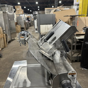 Chefmate Globe Series electric deli slicer, stainless steel, manual gravity feed, on legs, warning label visible.