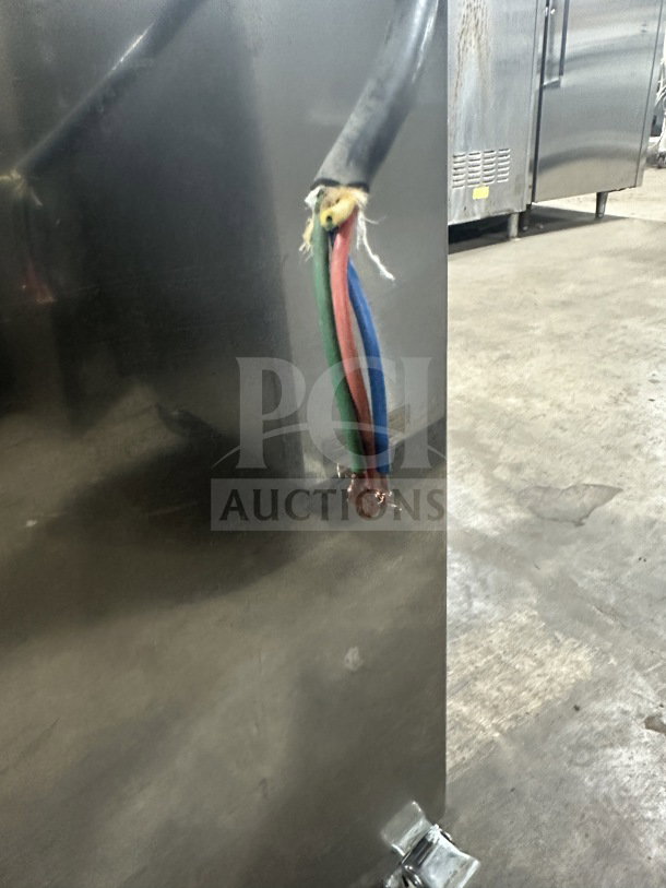 Commercial stainless steel gas-powered pneumatic pressure pot dispensing tank. Heavy-duty, on casters. Visible wear on cables.
