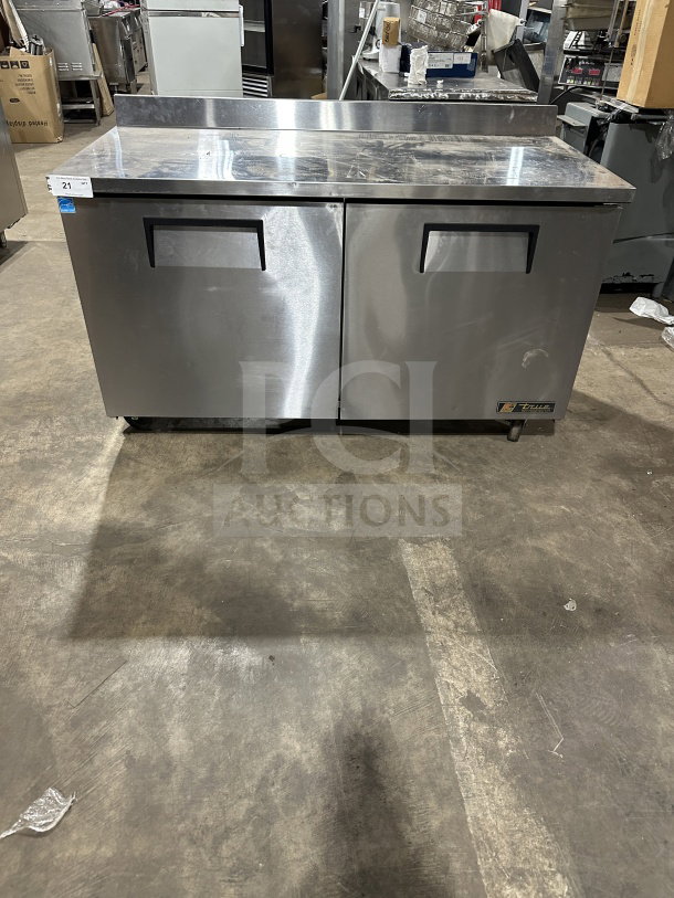 True TWT60 stainless steel 2-door refrigerated worktop table, upturned backsplash, poly-coated rack, on casters, Energy Star certified.