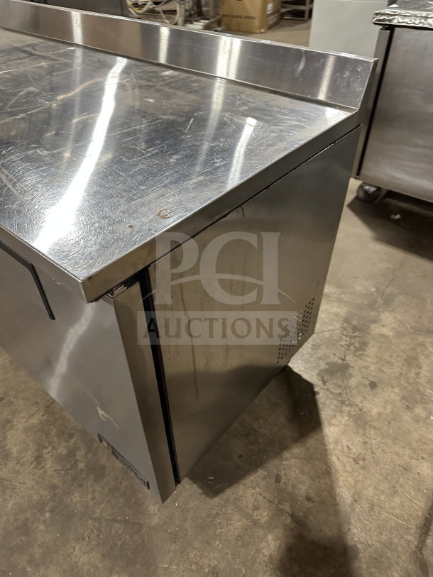 True TWT-60 stainless steel 2-door refrigerated worktop table. Features up-turned backsplash, poly coated rack, on casters.