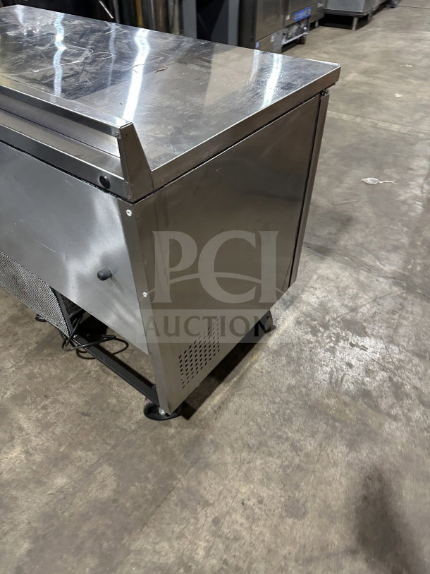 True TWT-60 stainless steel 2-door refrigerated worktop table with upturned backsplash, poly coated rack, on casters.