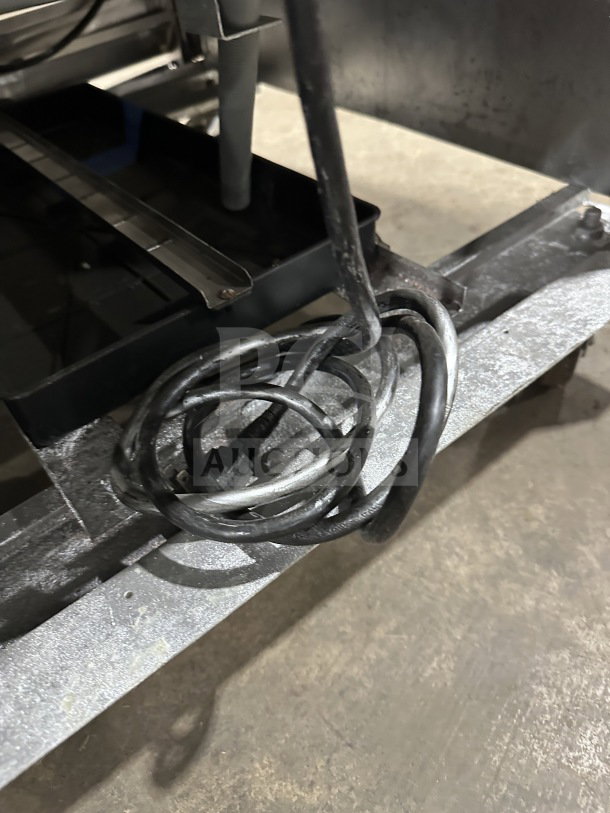 Coiled power cord for Atosa B Series MCF8707 commercial refrigerator on metal surface.