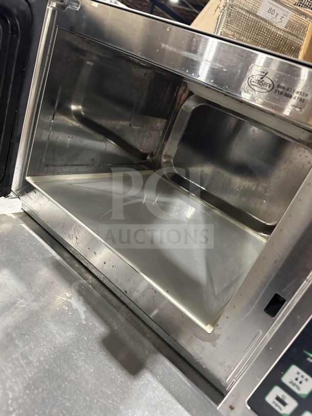 Amana 2023 Model RCS10DSE commercial stainless steel microwave with visible interior, slightly used condition.