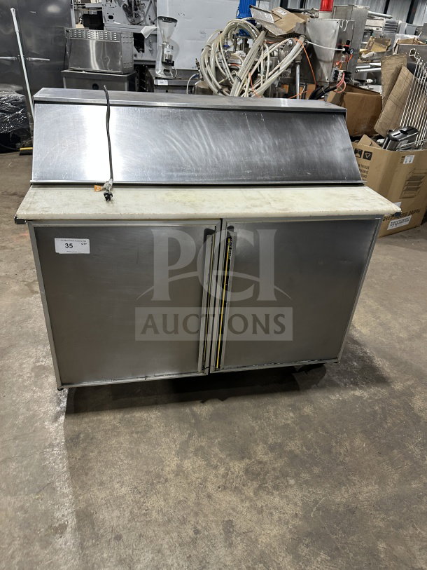 Commercial stainless steel 2-door refrigerated prep table with cutting board, on casters. Ideal for sandwich/salad prep.