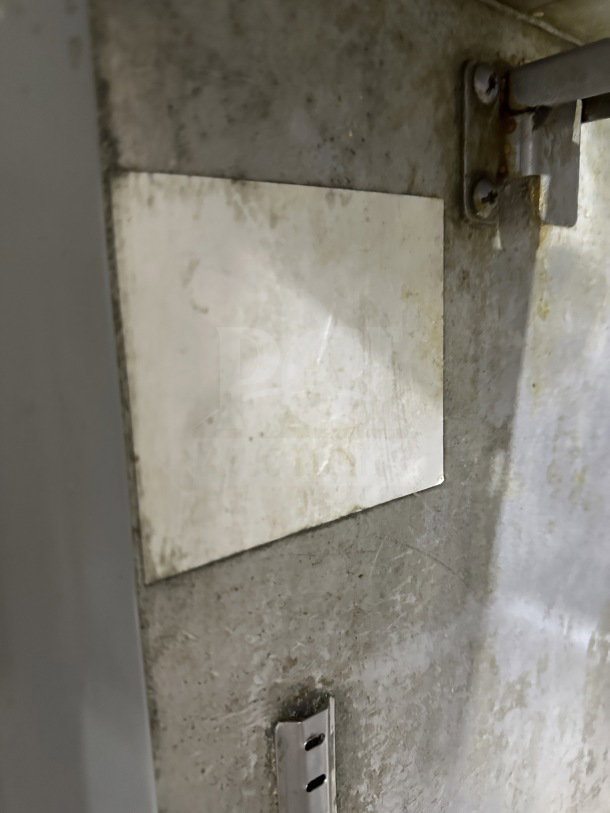 Commercial stainless steel 2-door refrigerated prep table with cutting board and casters. Shows worn condition. No markings visible.