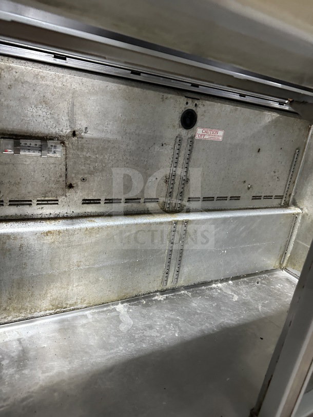 Commercial stainless steel 2-door refrigerated prep table, features cutting board, electric-powered, on casters, interior view.
