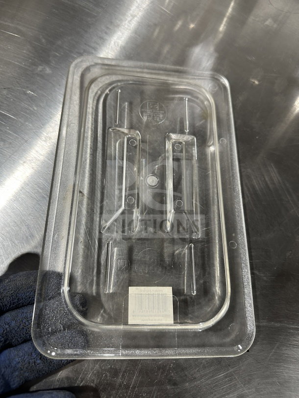 Thunder Group PLPA7130C commercial clear polycarbonate 1/3-size food pan lid on metal surface. Appears in good condition.