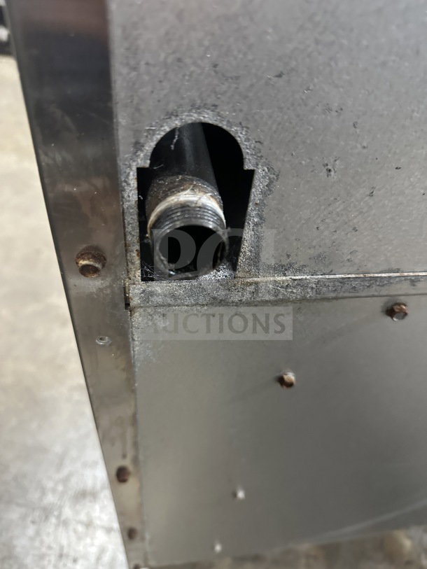 Close-up of Radiance stainless steel commercial range part, showing connection detail. Slight wear visible.