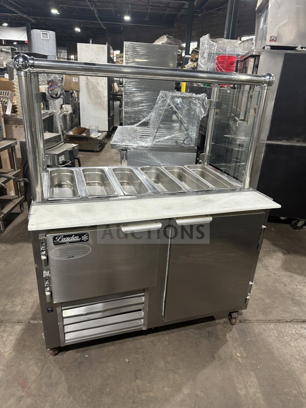 Leader stainless steel mobile 6-salad bar and cold food station, on casters. Features glass sneeze guard and dual compartments.