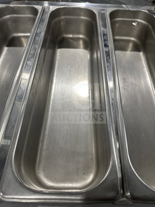 Leader stainless steel refrigerated salad bar, glass top, mobile on casters, visible interior compartments, good condition.