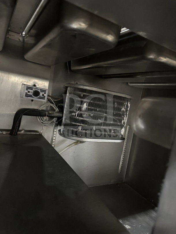 Leader stainless steel mobile refrigerated salad bar interior. Features cooling coils, wired connection, on casters.