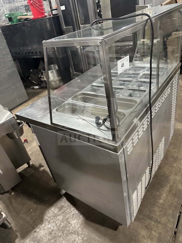 Leader commercial stainless steel refrigerated salad bar with full-glass sneeze guard. Features multiple topping slots.