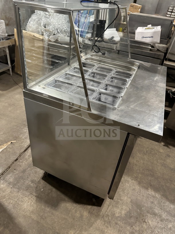 Leader stainless steel refrigerated salad bar with full-glass sneeze guard, excellent condition. Features multiple condiment trays.