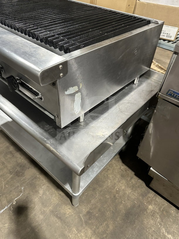 Radiance 36" stainless steel gas char broiler with cast iron grates and individual controls, on legs and stainless steel stand.