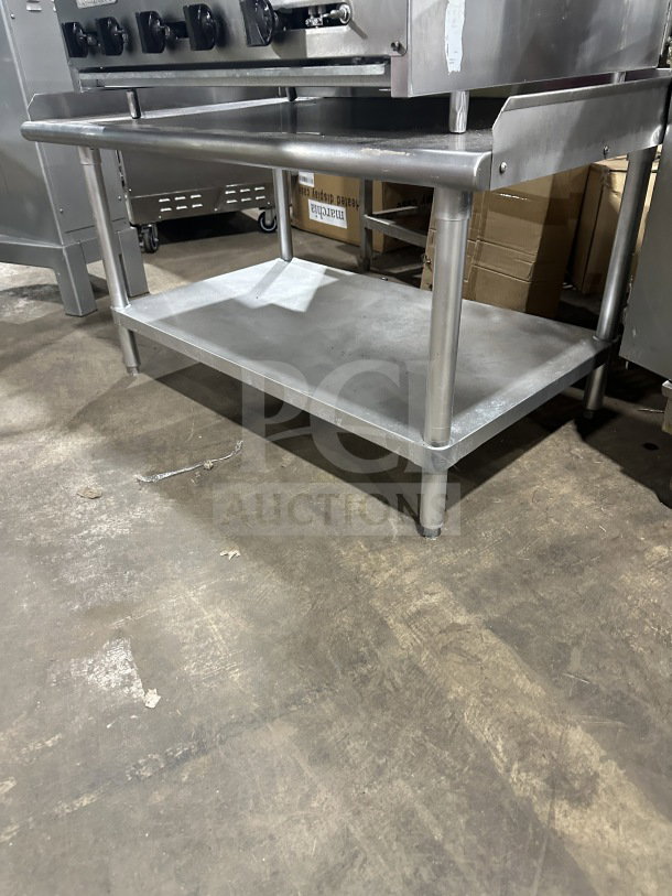 Radiance 36" stainless steel gas char broiler with cast iron grates, individual controls, on legs and stand.