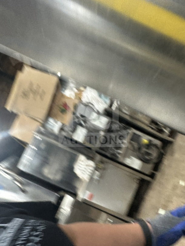 Blurred image showing a commercial kitchen setting with stainless steel equipment. Details of Avantco cabinet not visible.