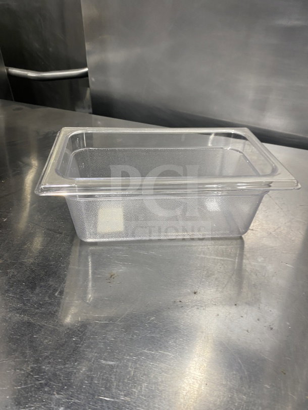Rubbermaid 4" commercial transparent polypropylene food pan, model 339600, in excellent condition on a metal surface.