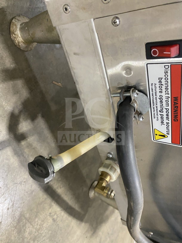 Fetco CBS-2142-XST coffee brewer base showing power switch, warning label, and plumbing connection; stainless steel construction.