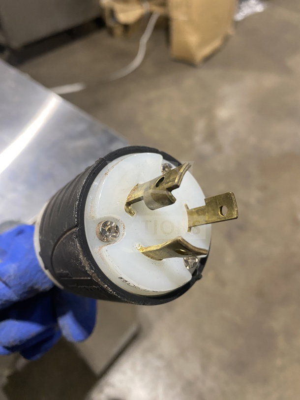 Close-up of plug for Fetco CBS-2142-XST automatic twin coffee brewer, showing metal prongs and black casing.