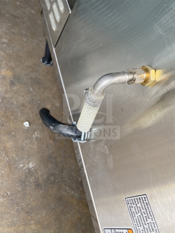 Bunn AXIOM 0/6 TWIN coffee brewer, stainless steel, with visible water connections and electrical label on side panel.