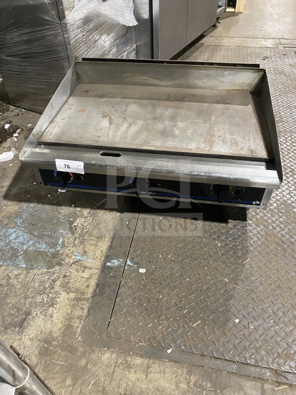 Star Max commercial stainless steel gas griddle with back and side splash, on legs. Slightly worn, model visible.