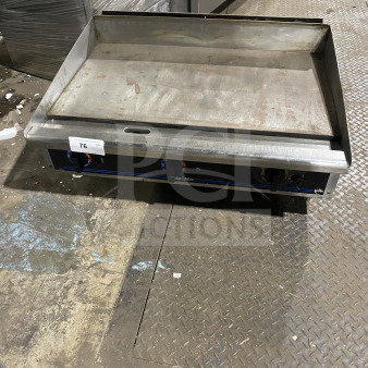 Star Max commercial stainless steel gas griddle with back and side splash, on legs. Slightly worn, model visible.