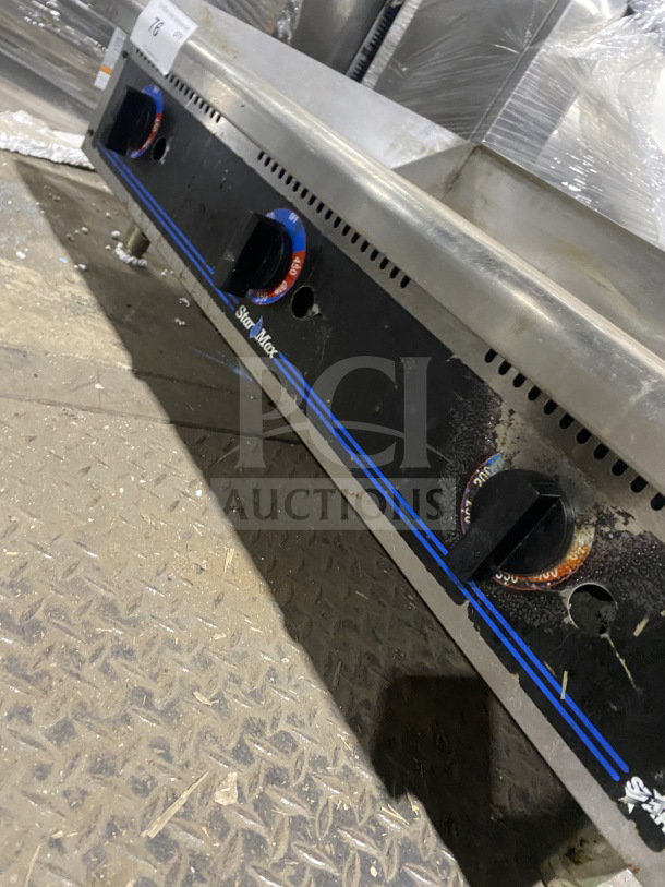 Star Max stainless steel gas flat-top griddle with back and side splash, on legs. Used condition, visible controls.
