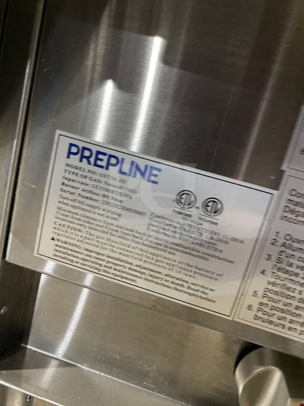 Prepline stainless steel two-well gas powered steam table with sneeze guard and undershelf. Visible label with model specs.