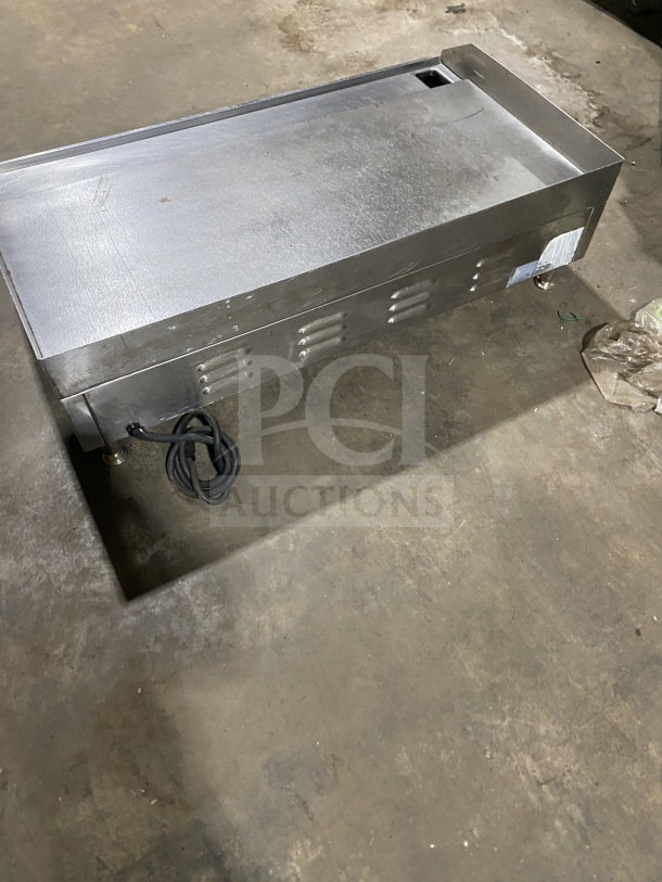 Commercial stainless steel electric countertop griddle with side and back splash, on legs, good condition, visible cord.