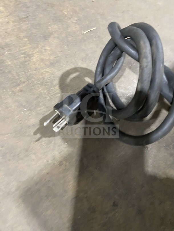 A coiled electrical cord for a commercial stainless steel electric countertop griddle.