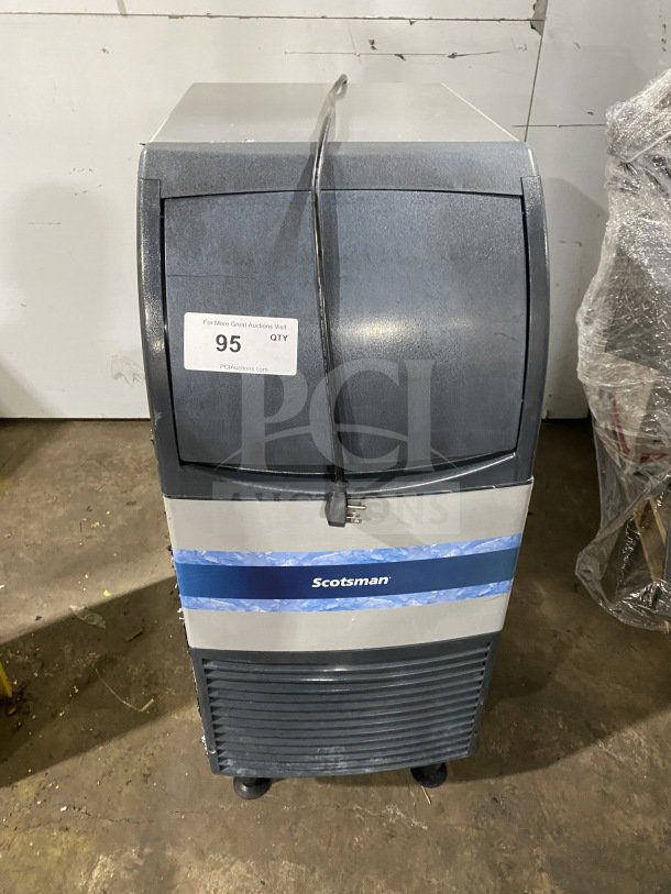 Scotsman commercial undercounter ice maker with built-in storage, electric powered, on casters, fair condition, auction tag visible.