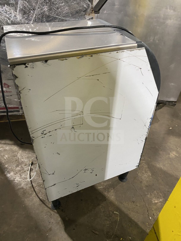 Scotsman undercounter cube ice maker with built-in storage bin, electric powered, on casters, shows surface wear.