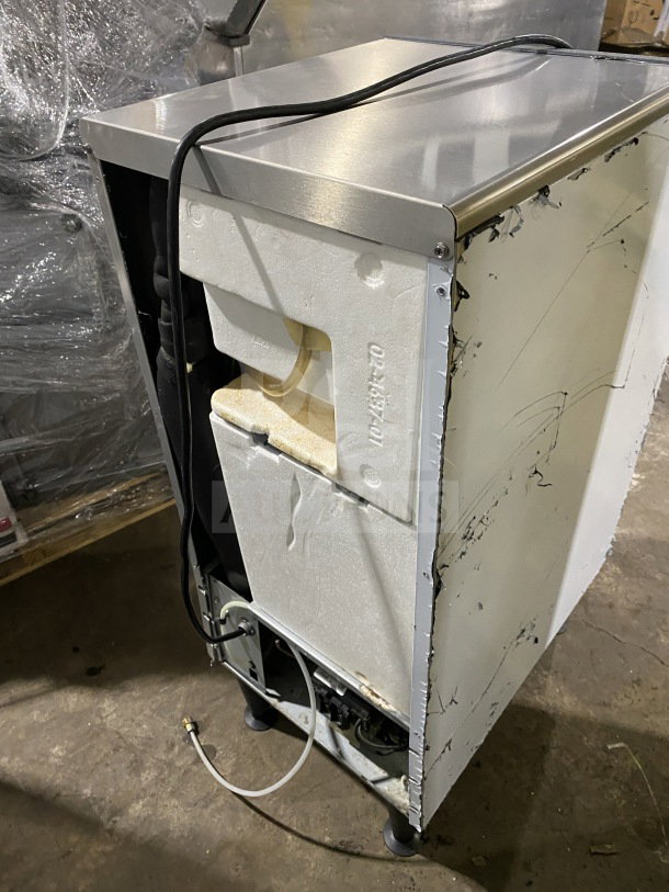 Scotsman commercial undercounter cube ice maker, electric-powered, with built-in storage bin, on casters. Visible scuffs.