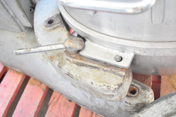 Close-up of Hobart M802 planetary dough mixer lock lever, showing wear and rust. Mixer includes bowl, dolly, guard, and hook.