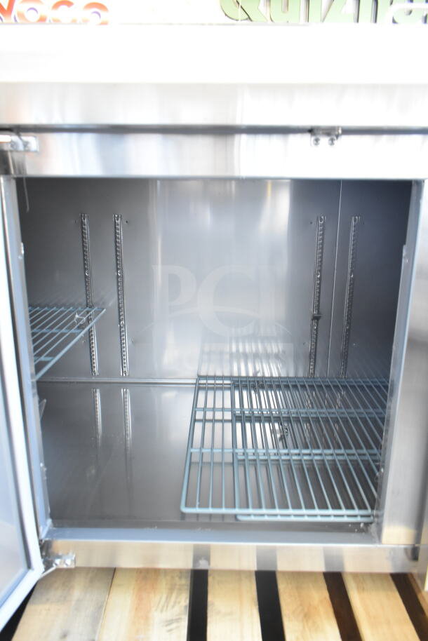 Brand new Avantco 178SSPPT3 commercial pizza prep table, 115V, 1 phase, interior view with shelves, slight scratches.