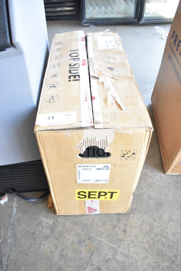 Cardboard box for Mahlkonig E80W GBS espresso grinder, labeled with model ME80W GbS, showing signs of handling wear.
