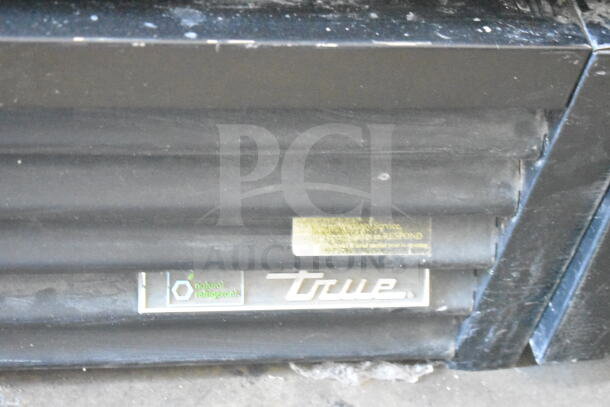 2016 True GDM-72F-HC 3 door freezer merchandiser, black exterior, visible "True" logo and "natural refrigerants" label.