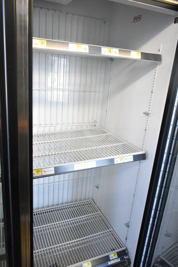 2016 True GDM-72F-HC commercial 3-door reach-in freezer merchandiser, tested and working, shelves visible inside.