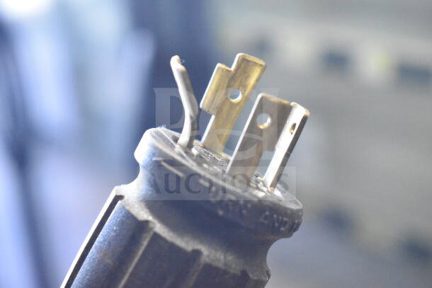 Close-up of electrical plug for a 2016 True GDM-72F-HC freezer, showing prongs and part of the casing.