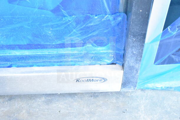 KoolMore CDC-49-SS bakery display fridge, 4-tier, scratch and dent, blue protective covering, KoolMore logo visible.