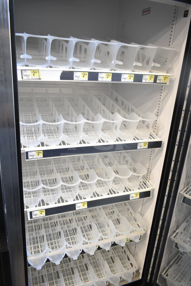 2016 True GDM-49-HC 2-door commercial cooler, tested working, interior shelves, price tags visible, 115 volts, 1 phase.