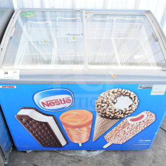 AHT RIO S 100 commercial freezer merchandiser on casters, featuring Nestlé branding. Tested and working, 115 volts, 1 phase.